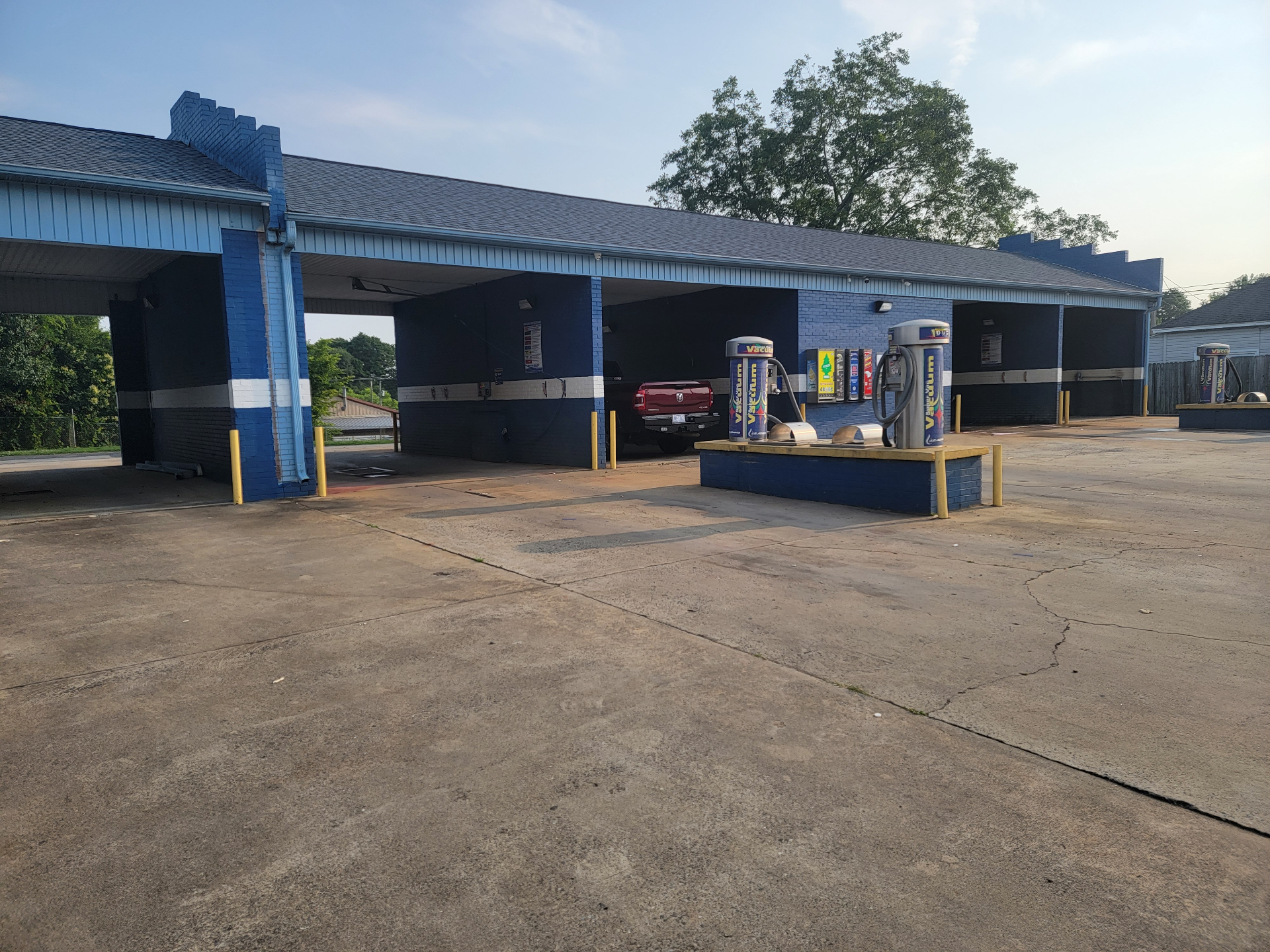 Covered self-serve wash bays and vacuum island at 609 E Trade Carwash